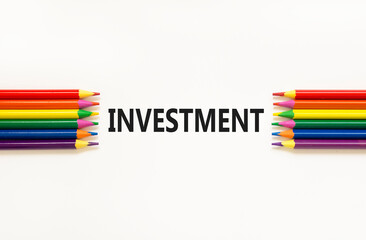 Fototapeta premium Investment symbol. Concept word Investment on beautiful white paper. Beautiful white paper background. Beautiful colored pencils. Business investment concept. Copy space.
