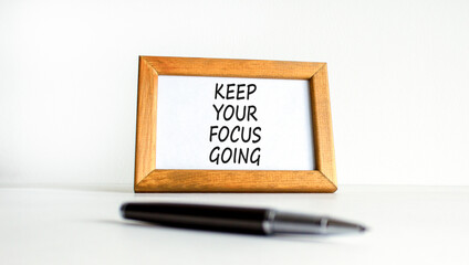 Keep your focus going symbol. Concept words Keep your focus going on beautiful wooden picture frame. Beautiful white table white background. Business and keep your focus going concept. Copy space.