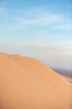 Khongor Sand Dunes in the Gobi Desert of Mongolia. Vast golden sand dunes stretching across the desert landscape, surrounded by mountains and showcasing the unique beauty of one of Mongolia&rsquo;s most ico