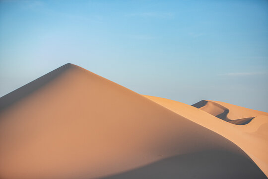 Khongor Sand Dunes in the Gobi Desert of Mongolia. Vast golden sand dunes stretching across the desert landscape, surrounded by mountains and showcasing the unique beauty of one of Mongolia&rsquo;s most ico