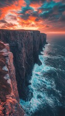 Steep cliffs rise dramatically over crashing ocean waves at sunset