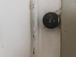 Wall damage near a circular electrical socket in a residential space