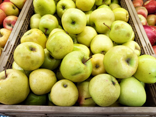 Fresh green apples stacked in a market display during the harvest season