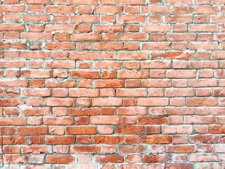 Fototapeta premium The rustic red brick wall displays variations in texture and color, reflecting natural light beautifully