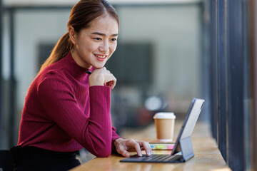 smart casual asian female startup entrepreneur small business owner business woman smile hand use tablet at workplace.
