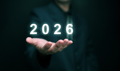 Happy new year 2026. A businessman holds changing year on his hand, ready to start or begin 2026.