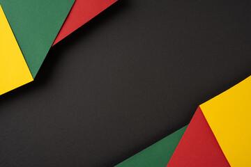 Colorful paper textures featuring green, yellow, and red pieces arranged on a black background