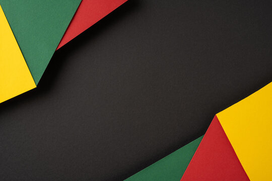 Colorful paper textures featuring green, yellow, and red pieces arranged on a black background