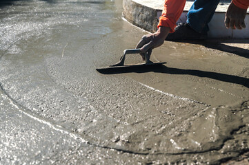 Mason worker using trowel leveling wet mixing cement in construction site