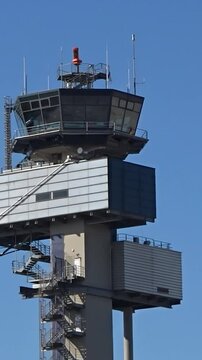 airport control tower stands tall against backdrop clear blue sky radar top crucial for air traffic management essence aviation rotating static shot atc observation safety navigation 
