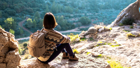 Woman in the mountains. Girl traveling in the mountains. Trekking and hiking. Girl with a backpack.