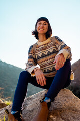 Naklejka premium Portrait of happy female tourist in mountains. girl smiles. trekking and hiking. girl with backpack.