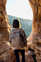 girl with a backpack. A woman with a backpack stands in a cave. The girl explores the cave. Tour of...