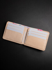 Blank open brown men's leather wallet isolated on black background, perfect for leather industry catalog design