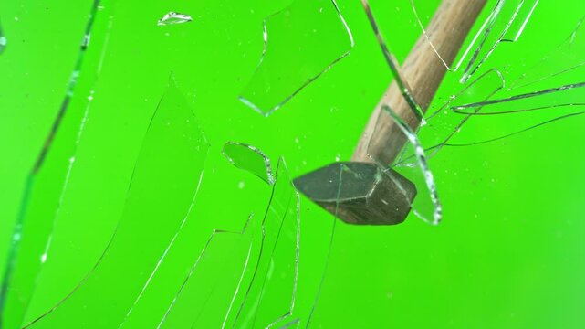 Super slow motion of glass-breaking hammer, shattering against green screen background . Filmed on high speed cinema camera, 1000 fps .