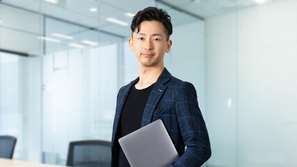 ノートパソコンを抱える男性ビジネスマン