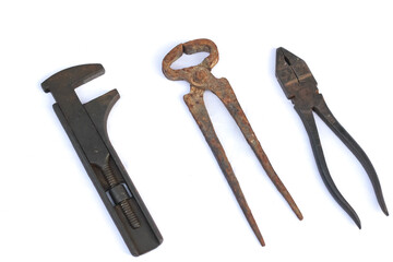 Construction worker equipment in the form of iron cutting pliers, monkey wrench, rusty wire pliers isolated on white background