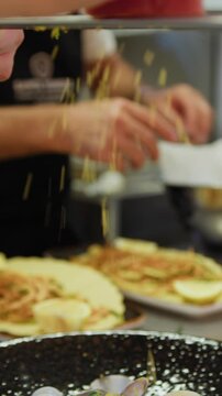 Chef is Grating Bottarga into a Plate of Italian Spaghetti with Clams