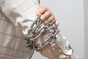 Arthritis symptoms, suffering from pain. The hands of the senior man massage a painful elbow. Chain symbolizing inflamed male joint, stiffness of movement. Old age, health. Close up view..