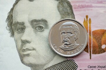 Ukrainian silver coin lies on one hundred hryvnia bill. Financial and business concept. Modern...