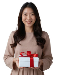 A smiling Asian woman with both holds a red gift box, wearing a beige sleeveless dress.