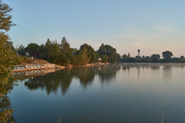 Sunrise over the lake. Fishing on the lake. Reflection in water.