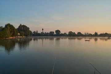 Naklejka premium Sunrise over the lake. Fishing on the lake. Reflection in water.