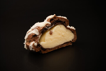 Profiteroles with coconut cream on a black background.