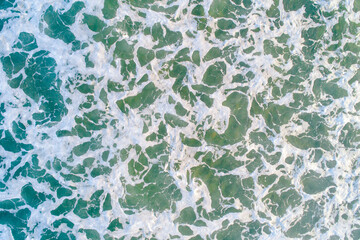 close-up zenith view of seawater on the shore of a beach, textured background marine concept