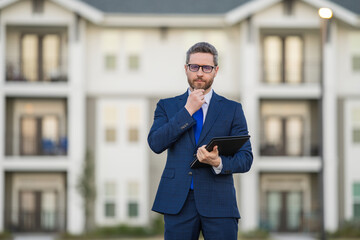 Real estate agent business man in suit hold holder clipboards outside. Hispanic Businessman. Business Man broker or real estate agent. Business man in suit outdoor. Real estate business man.