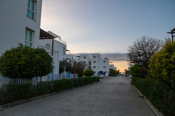 Serene sunset along a quiet pathway in a charming coastal neighborhood