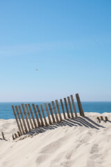 seascape background scene. Coastal summer background. Sand dune with wood fence and sea in the distance. Sunny day at the beach detail