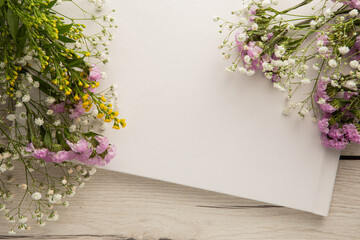 Flatlay of a blank book or photo album with flowers for mockup