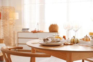 Stylish table setting with beautiful dishware and autumn decor in dining room