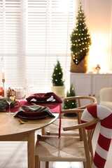 Christmas table setting with stylish dishware and festive decor indoors