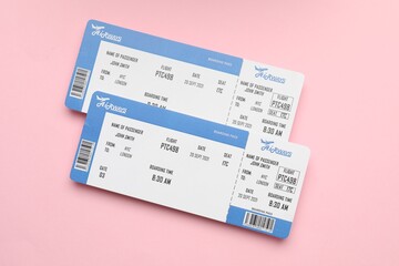 Travel agency. Flight tickets on pink background, top view