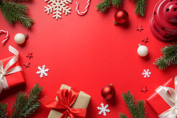 Christmas presents on red background. Gift boxes, fir tree and decorations.