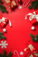 Christmas composition with gifts and decorations. Flat lay image on red background.