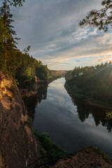 eagle cliffs near Cēsis on a sunny summer evening after rain with a reflection in the river.
