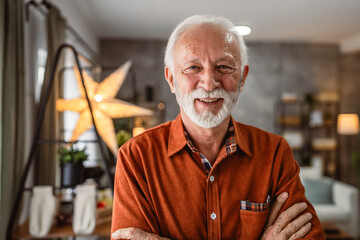 portrait of senior man stand with arm crossed at home