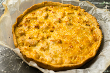 Delicious French quiche pie with chicken and cheese. Baking process, pie cooling on baking parchment