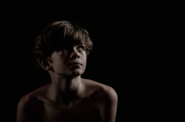 Portrait of a little boy on a dark background