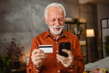 senior mature man buy online on cellphone with credit card at home