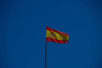 The Spanish national flag flies on a flagpole 