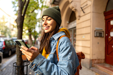 A young woman exploring the city, using her phone to double-check the route