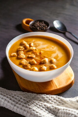 Pumpkin soup served on the table. Pumkin cream soup with rusks. Cozy atmophere at home. Staying at home and eating homemade food, nesting concept