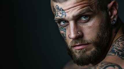 Fototapeta premium A man with tattoos and a nose ring is staring at the camera