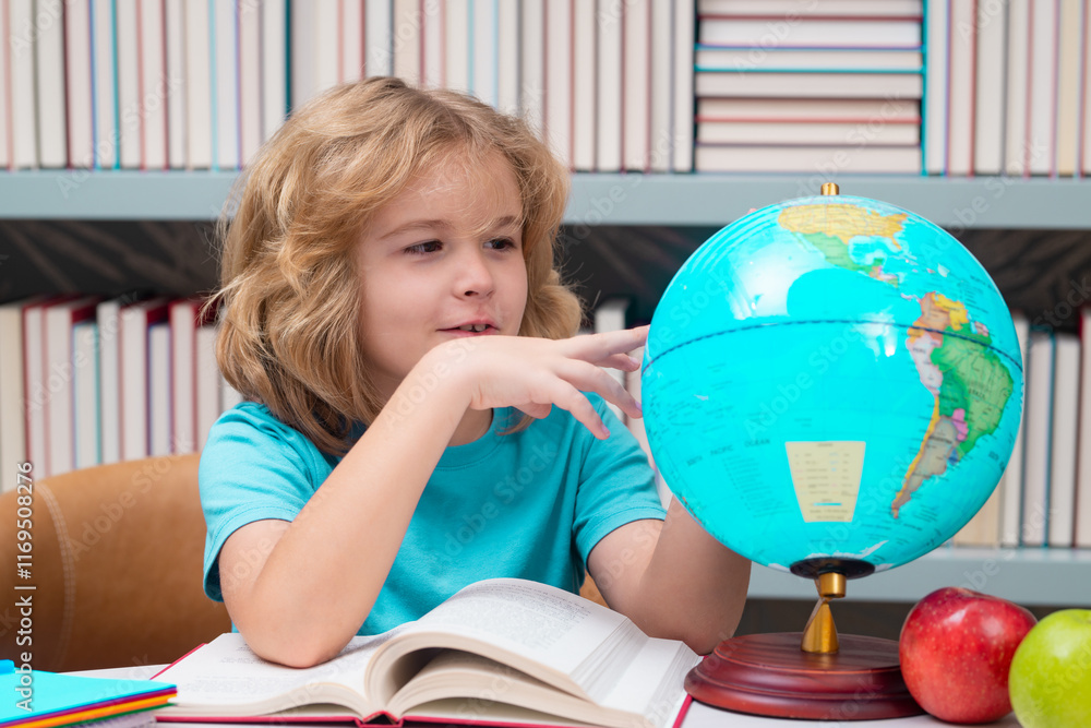 Leinwandbilder school pupil looking at globe in library, geography lesson. school child studying in classroom at el