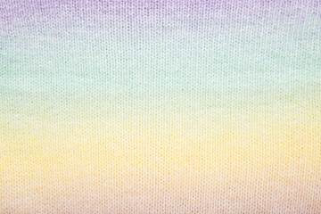 Light colorful soft knitted fabric pattern background. Closeup. Top down view.