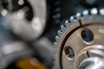 Close-up view of industrial metal gears in motion, symbolizing engineering, machine building, machine construction and precision manufacturing, disassembled car engine, spare parts. Selective focus